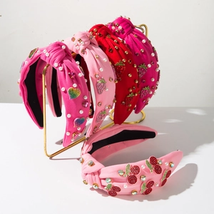 Detail view of colorful knot headbands with rhinestone cherries and pearl strawberry patches
