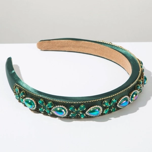 Macro detail of emerald green satin headband with floral rhinestone and crystal patterns
