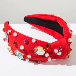 Detail of red knotted headband with pearls, rhinestones and Mother's Day enamel badges