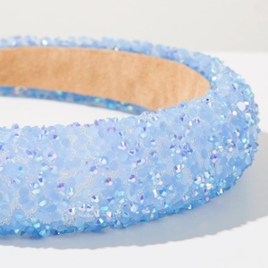Close-up of light blue rhinestone headband showing shimmering crystals and velvet lining