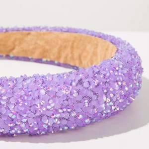 Detailed close-up of a purple beaded headband featuring sequins and luxury craft texture