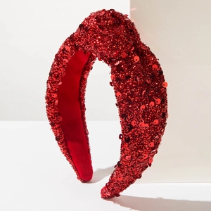 Macro shot of sparkling red sequin knotted headband with a shimmering festive texture