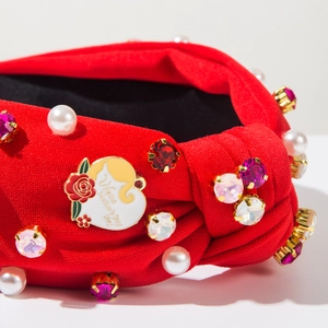 Detail of red fabric headband with pearls, rhinestones and Happy Mother's Day heart charm