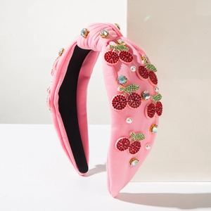 Detail of pink knotted headband with rhinestone cherry patterns and white pearls