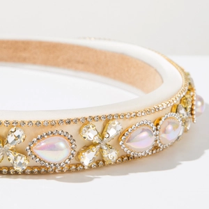 Detail of baroque headband featuring colorful pearls, rhinestones and beige satin fabric