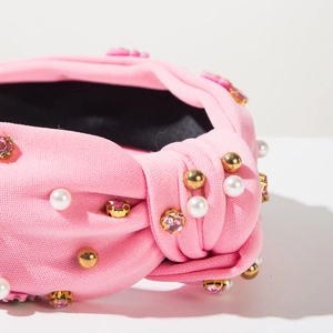 Detail of pink knotted headband featuring faux pearls and sparkling pink rhinestones
