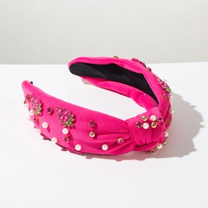 Detailed close-up of pink fabric headband with faux pearls and sparkling strawberry beads