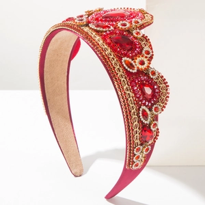Detail van barokke diadeem met rode strass-steentjes, fluweel en gouden borduurwerk