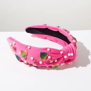 Close-up of pink knot headband with rainbow glitter hearts, pearls and rhinestones