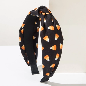 Detail of knot headband with orange and yellow candy corn print on black fabric