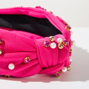 Close-up of fuchsia knotted headband with white pearls and pink rhinestones