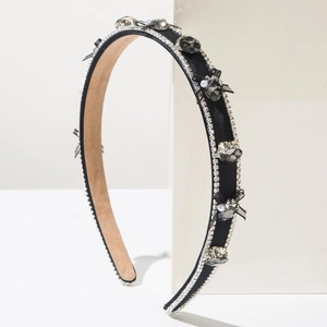 Détail du serre-tête noir avec cristaux étincelants, nœud en soie et perles blanches