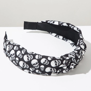 Detail of a wide twisted headband with a white skull print on black fabric for Halloween