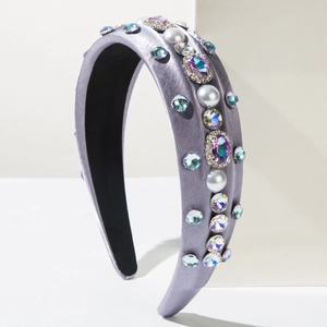 Détail du serre-tête en satin gris orné de perles artificielles et strass multicolores