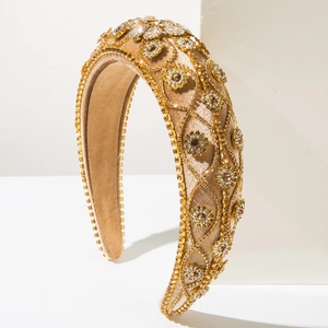 Close-up of champagne gold baroque headband with luxury crystals and velvet texture
