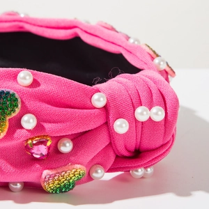 Detail of rose pink knotted headband with heart crystals and white pearls decoration