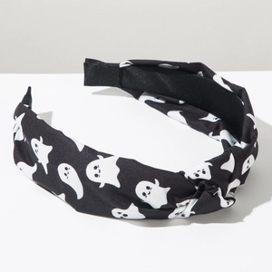 Close-up of Halloween knotted headband featuring white cartoon ghost prints on black fabric