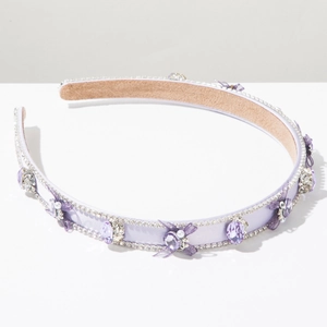 Détail du serre-tête lilas orné de cristaux, petits nœuds en résille et perles blanches