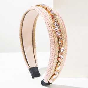 Macro detail of bohemian braided headband featuring pink crystals and woven texture