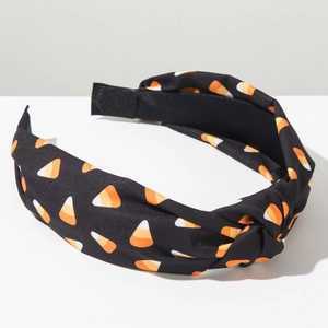 Detail of Halloween wide headband with candy corn print on a black fabric background