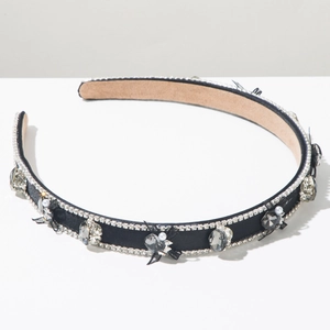 Détail du serre-tête en satin noir avec strass, perles et petits nœuds en maille