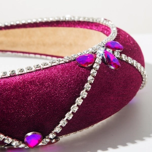 Macro detail of magenta velvet headband with rhinestone chains and teardrop crystals