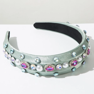 Détail du serre-tête en satin vert clair avec perles blanches et strass roses