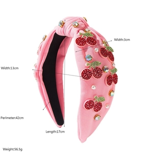 Pink knotted headband with rhinestone cherry and pearl embellishments on knit fabric