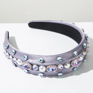 Détail d'un serre-tête rembourré lilas avec cristaux de luxe et perles blanches