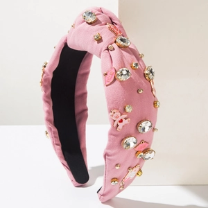 Detail of pink denim knotted headband with crystal bear and kiss me enamel charms