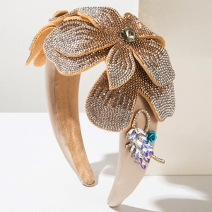 Détails du serre-tête baroque avec strass, fleurs dorées et une pierre précieuse verte