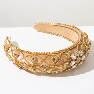 Detail of luxury baroque headband with gold crystals and sequins on champagne velvet