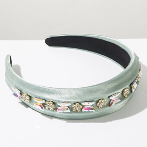 Détail d'un serre-tête en satin vert haricot orné de papillons et de fleurs scintillantes