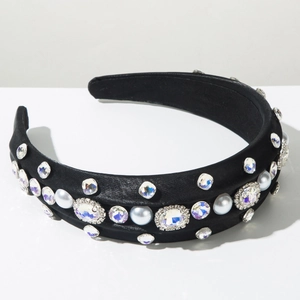 Gros plan sur un serre-tête large en satin noir orné de strass brillants et perles