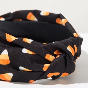 Detailed close-up of a knotted Halloween headband with festive orange candy corn patterns