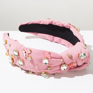 Detail of pink knotted headband with bear charms, kiss lips, and sparkling rhinestones
