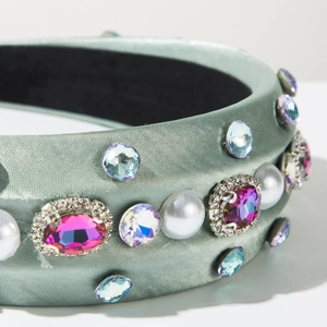 Vue macro d'un serre-tête en soie grise avec des strass et des détails de perles