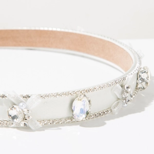 Vue détaillée du serre-tête nœud en strass avec tissu satiné et accents de perles