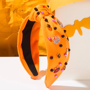 Detailaufnahme eines orangefarbenen Halloween-Haarreifs mit Perlen sowie Kürbis- und Geist-Anhängern