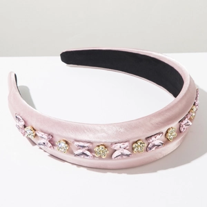 Détail d'un serre-tête en satin rose avec papillon en cristal et fleurs strassées