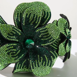 Macro d'un serre-tête baroque avec strass verts et cristal taillé en forme d'émeraude