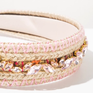 Detail of bohemian straw headband with pink crystals and intricate woven cross-stitch texture