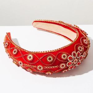 Close-up of luxury Baroque headband with red velvet and intricate rhinestone patterns