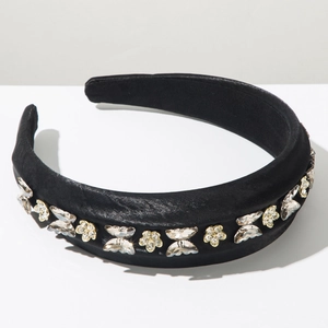 Détail d'un serre-tête en satin noir rembourré avec papillons et fleurs en strass brillants