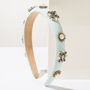 Detailed shot of retro fabric headband with rhinestones, pearls and golden embroidery