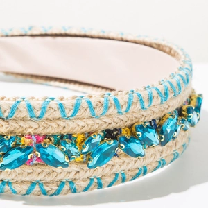 Detailed close-up of woven headband with blue rhinestones and cross-stitch embroidery