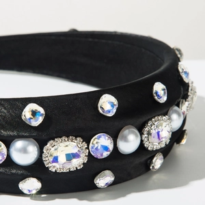 Détail d'un serre-tête en satin noir avec des perles et des cristaux scintillants