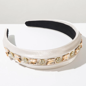 Détail d'un serre-tête rembourré en satin avec cristaux et motifs de fleurs et papillons
