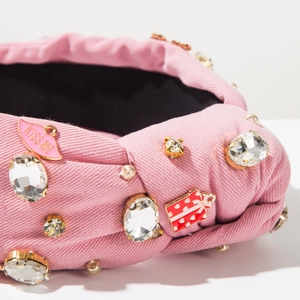 Detail of pink knotted headband with rhinestone bear and KISS ME enamel charms