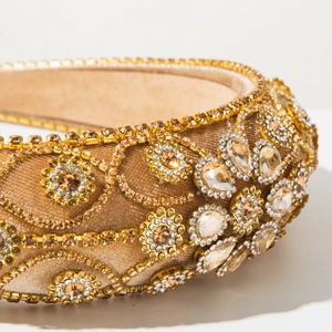 Detailed close-up of champagne crystal floral pattern on luxury velvet baroque headband